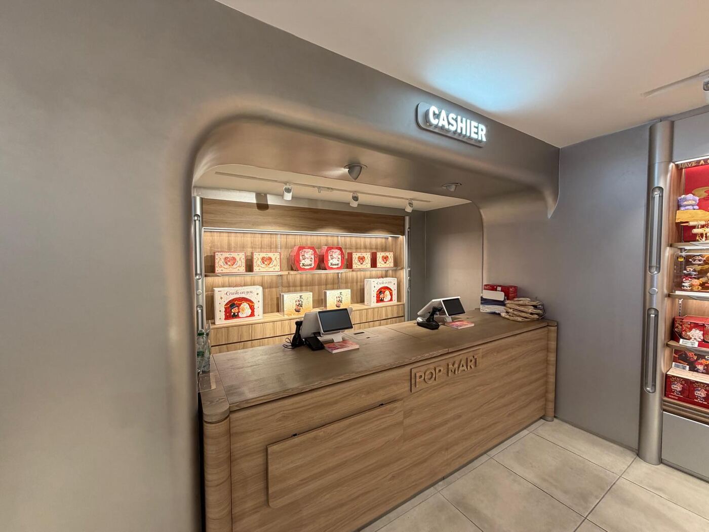 Pop Mart Charing Cross — finished cashier counter with curved overhead canopy
