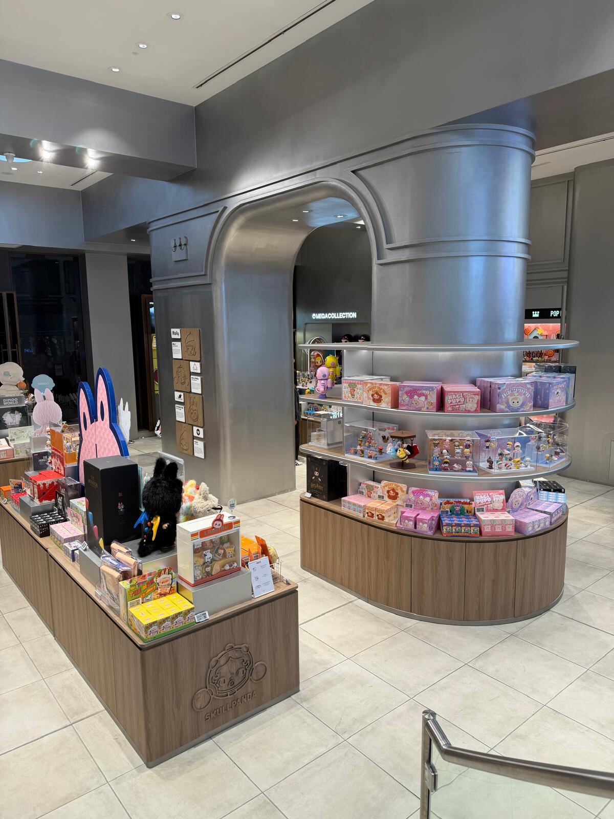 Pop Mart Charing Cross — finished store with steel-clad archway and circular display column